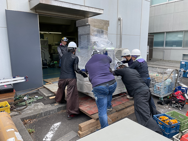 研究施設での搬入作業です。4トンもの重量物を弊社メンバー6人が人力で押して建屋へ搬入しています。